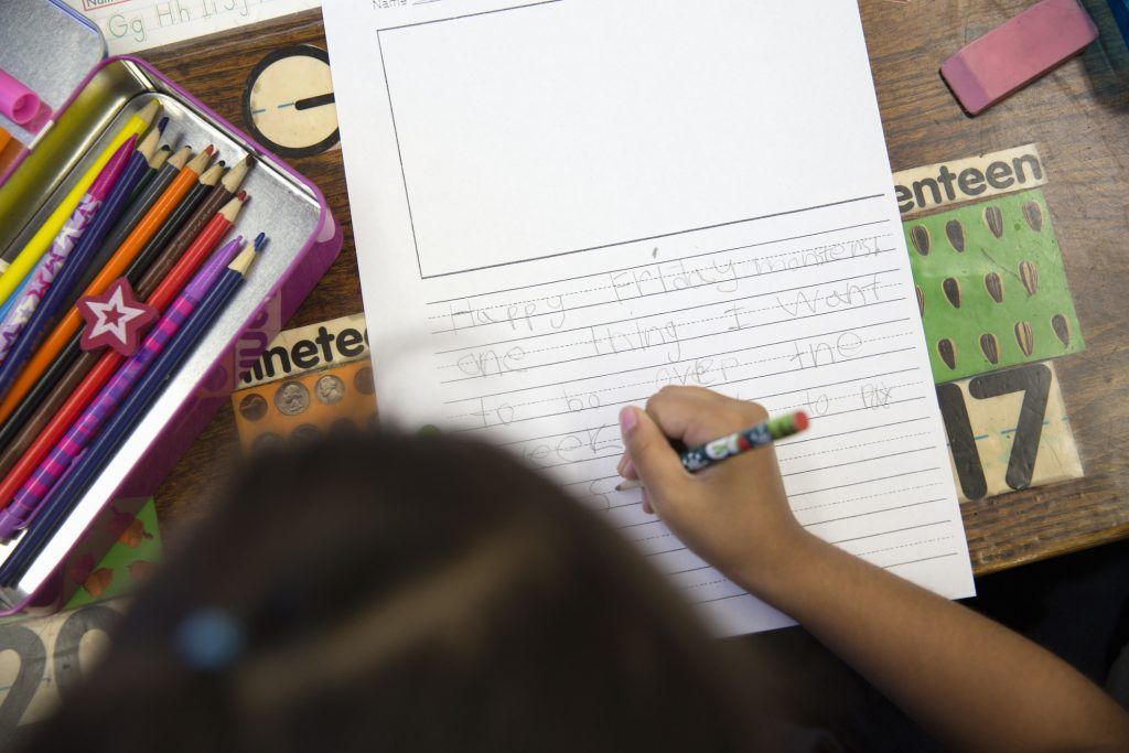 Overhead view of student learning to write.