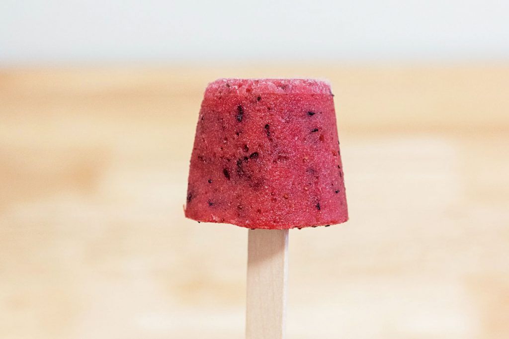 how to make planet-friendly ice lollies: a finished ice lolly is bright red and sits at the end of the stick
