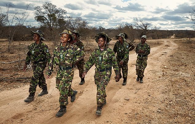 a team of female wildlife rangers march forward in rows