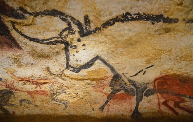 an ancient cave painting of a horned cow, made from rough charcoal lines