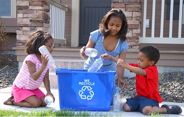 a family puts recycling in a blue bin