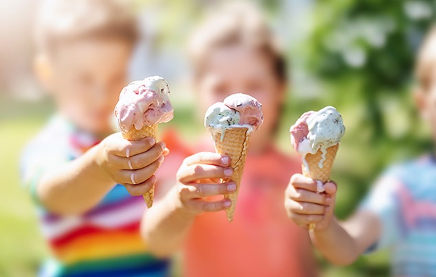 three kids hold ice cream in waffle cones