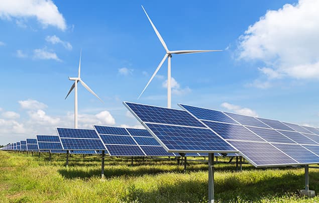 sdgs | solar panels and wind turbines against a blue sky