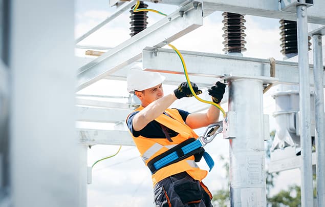 sdgs | a man wearing a reflective jacket repairs an electrical system