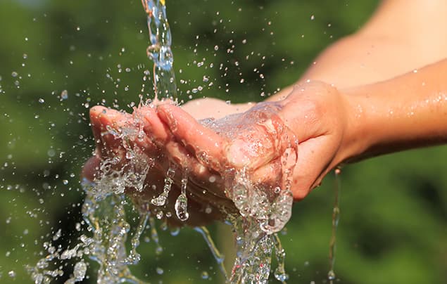 sdgs | fresh, clean water pours over cupped hands