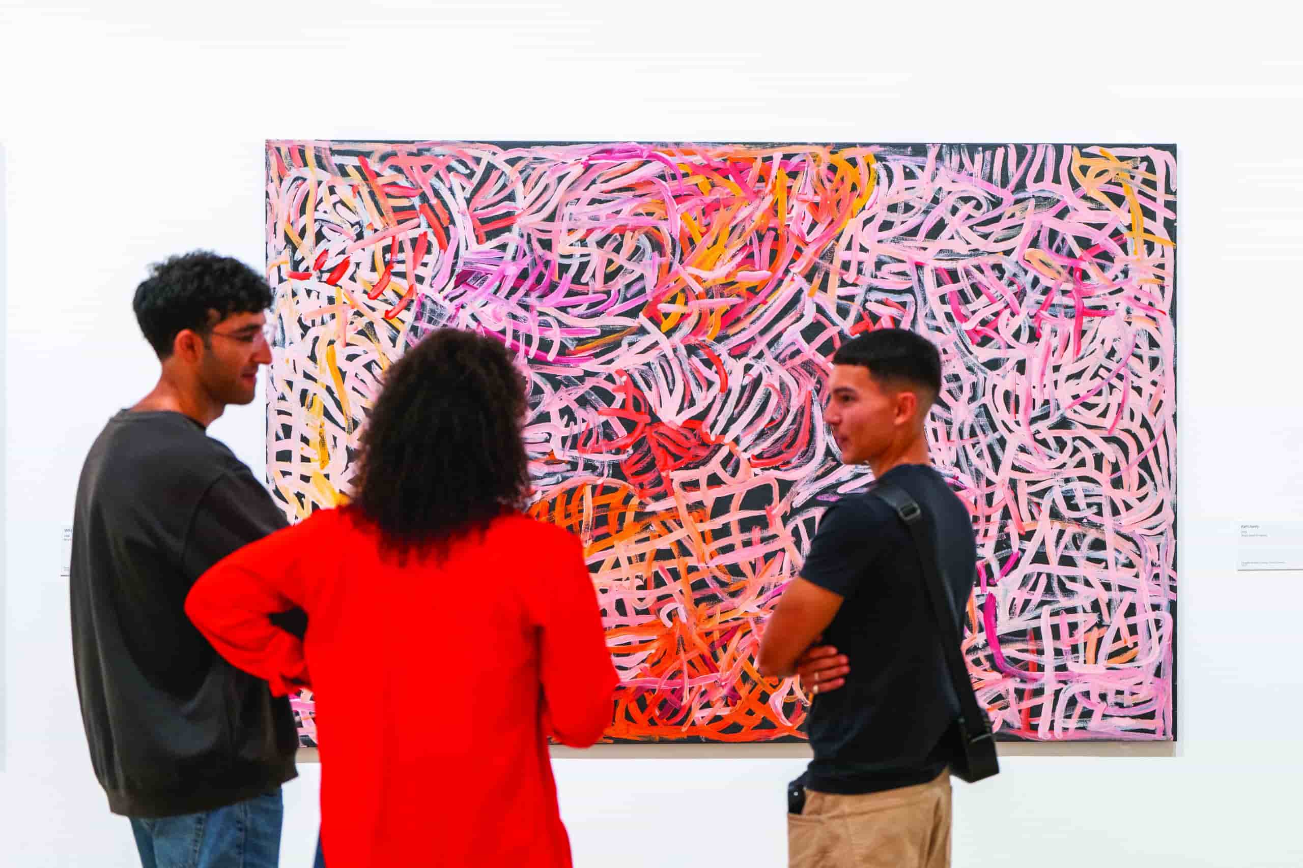 two parents and a child stand in front of one of Emily's vibrant artworks