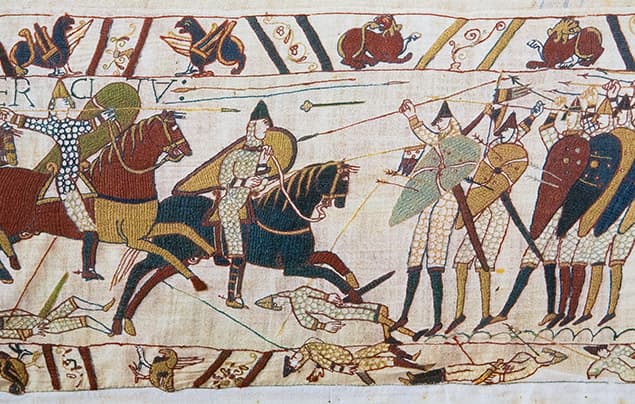 Detail from the Bayeux Tapestry showing armoured soldiers on horses and on foot in battle, with fallen fighters on the ground and archers aiming bows.