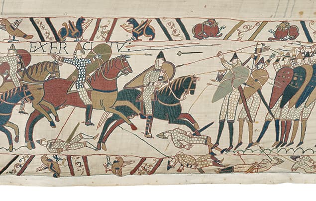 A scene from the Bayeux Tapestry showing soldiers on horseback and on foot in battle, with arrows flying and several fallen figures on the ground.