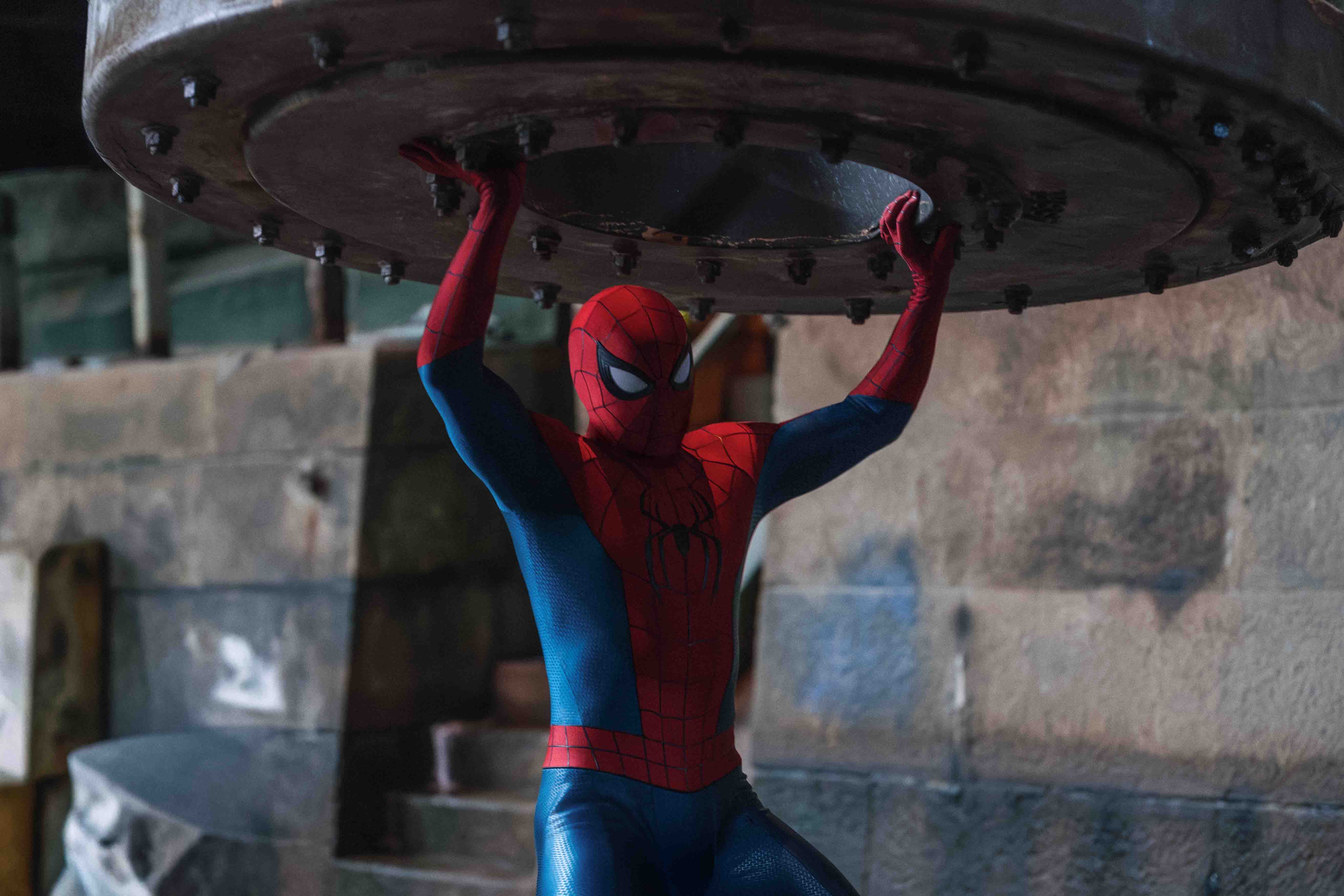 Spider-Man holds up a large metal structure during a high-stakes adventure.